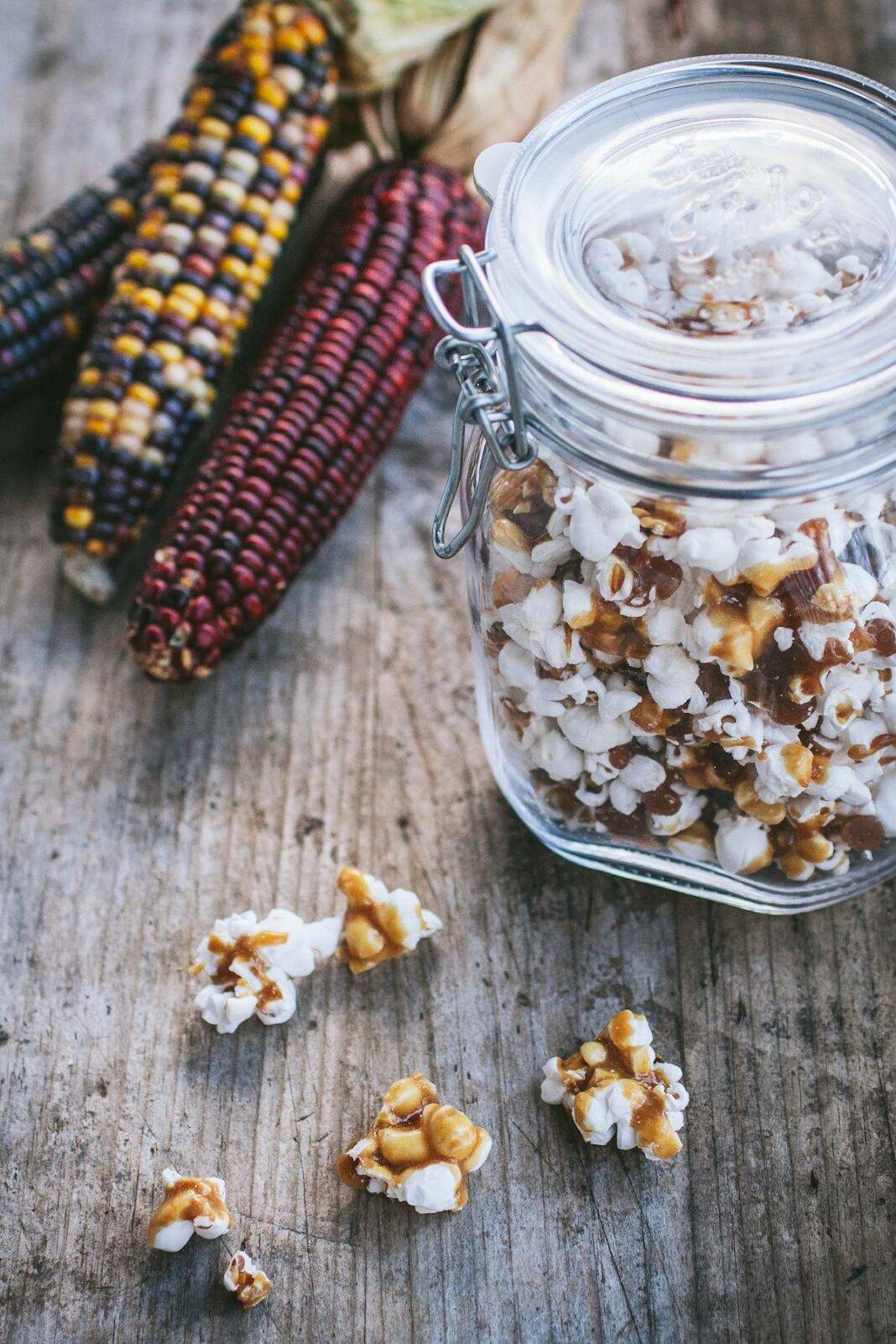 Maple Caramel Corn in a jar with Indian Corn next to it on the table